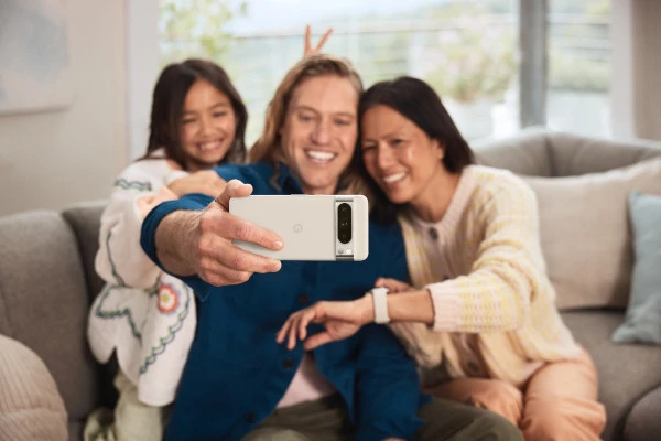 Eine Familie auf dem Sofa macht ein Selfie mit dem Google Pixel 8 Pro.