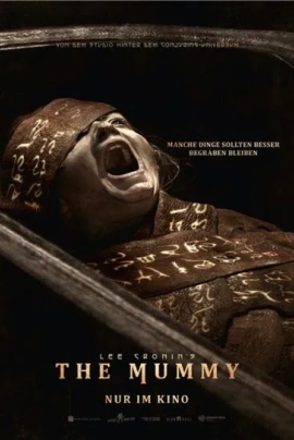 Ein düsteres Horrorplakat zeigt eine mumifizierte Gestalt im Zentrum, teilweise von Bandagen umhüllt. Sand und Dunkelheit dominieren die Szene, während das Gesicht der Figur bedrohlich aus dem Schatten hervortritt. Der Titel ist rau und verwittert gestaltet.