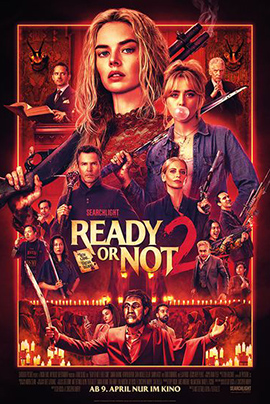 Filmplakat zu „Ready or Not 2“: Vor einem intensiven roten Hintergrund ist zentral eine junge Frau mit entschlossenem Blick zu sehen, die ein Gewehr über der Schulter hält. Um sie herum sind mehrere Figuren aus verschiedenen Szenen arrangiert – einige tragen Waffen, andere wirken angespannt oder bedrohlich. Kerzen und düstere Details erzeugen eine unheimliche, ritualartige Atmosphäre.