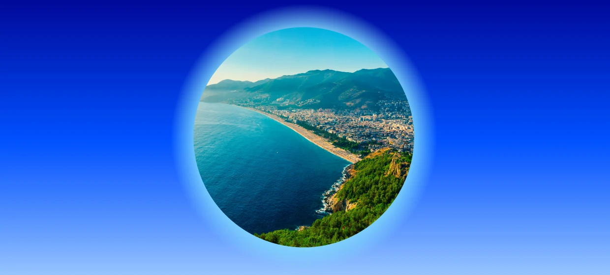 Luftaufnahme von Alanya in der Türkei mit Strand, blauem Meer und grünen Bergen. 