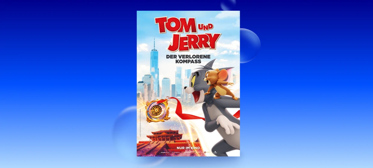  Filmplakat des Films TOM UND JERRY: DER VERLORENE KOMPASS. Vor einer hellen Skyline mit Wolkenkratzern rennt Tom im Vordergrund mit offenem Maul nach rechts, während Jerry auf seinem Rücken steht. Links schwebt ein leuchtender, goldener Kompass mit rotem Band. Unten ist ein rot beleuchteter Tempel zu sehen. Oben steht groß der Titel TOM UND JERRY, darunter DER VERLORENE KOMPASS, unten mittig NUR IM KINO. 