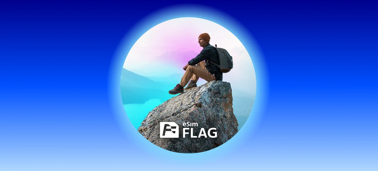  Mann sitzt auf einem Felsen und blickt auf eine bergige Landschaft. 