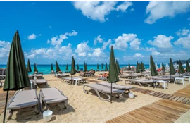  Ein Strand am Meer mit Liegen und Schirmen 
