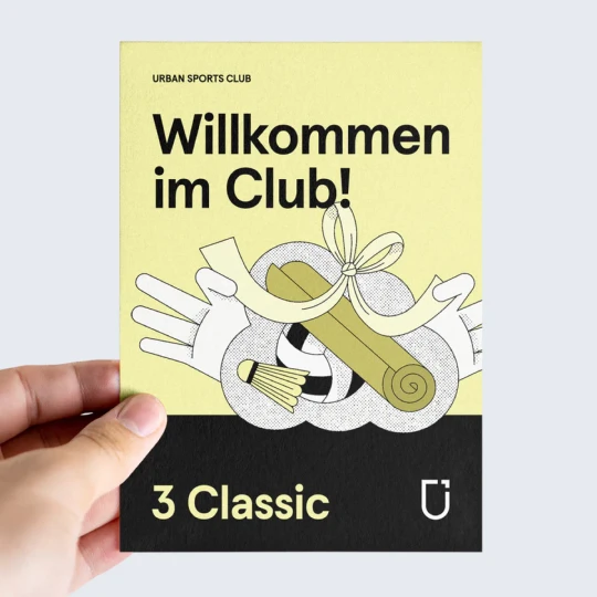  Eine Hand hält einen 3 Monat Urban Sports Club Classic Geschenkgutschein in den Händen 