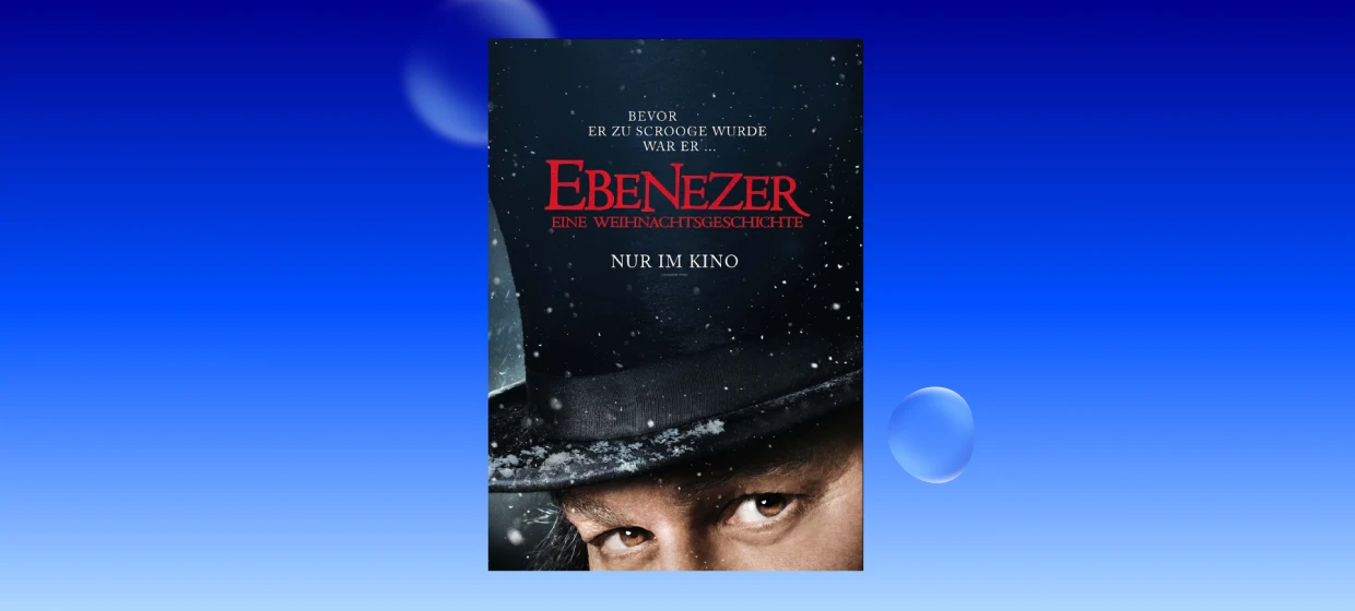  Filmplakat zu „Ebenezer – Eine Weihnachtsgeschichte“: Nahaufnahme eines Gesichts unter einem schwarzen Zylinderhut mit Schneeflocken. Auf dem Plakat steht: „Bevor er zu Scrooge wurde war er … Ebenezer – Eine Weihnachtsgeschichte. Nur im Kino.“ 