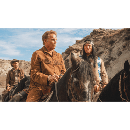Abahachi und Ranger reiten jeweils auf einem Pferd nebeneinander her. Abahachi sieht Ranger skeptisch an. Im Hintergrund sind eine weitere Person auf einem Pferd sowie eine trockene Landschaft zu erkennen.