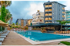  Eine Große Hotelreihe hinter einem Pool mit liegen und Schirmen 