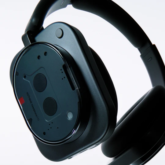  Seitenansicht des Nothing Headphone (1) in Schwarz auf hellgrauem Hintergrund. Gezeigt werden das Design des Kopfhörers und der Schriftzug NOTHING headphone (1). 