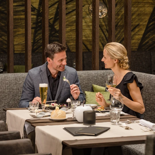  Zwei Personen sitzen im Restaurant beim Abendessen und unterhalten sich in gemütlicher Atmosphäre. 