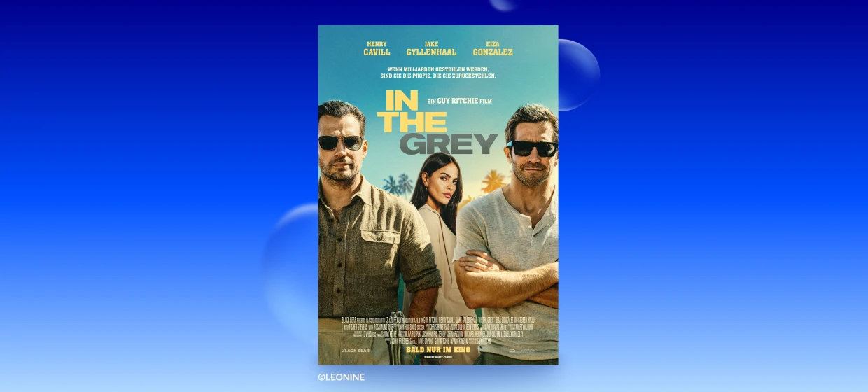 Auf dem Filmplakat "IN THE GREY" sind 3 Personen vor sonnigem, blauem Himmel und Palmen. Links und rechts 2 Männer mit Sonnenbrillen im Vordergrund. Mann rechts mit verschränkten, links mit herabhängenden Armen. In der Mitte, weiter hinten eine Frau mit langen dunklen Haaren & hellem Blazer. Oben stehen die Namen der Hauptdarsteller. Darunter Wenn Milliarden gestohlen werden, sind sie die Profis, die sie zurückstehlen. Mittig EIN GUY RITCHIE FILM & Filmtitel. Unten Credits und BALD NUR IM KINO. 
