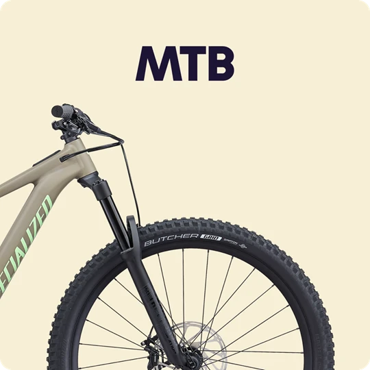  Nahaufnahme des vorderen Teils eines Mountainbikes mit breiten Reifen und Federgabel vor beigem Hintergrund. Darüber steht der Text „MTB“. 