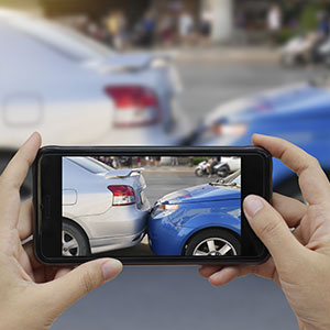 Person fotografiert Kfz mit Handy