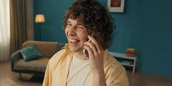  Mann, der lächelnd mit seinem Smartphone einen WLAN-Call tätigt.
