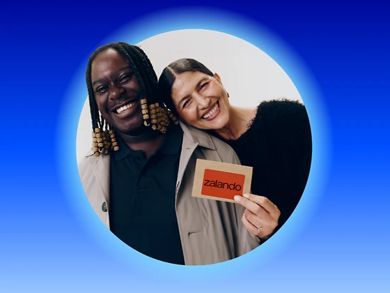  Ein Mann und eine Frau freuen sich über einen orangen Zalando-Gutschein 