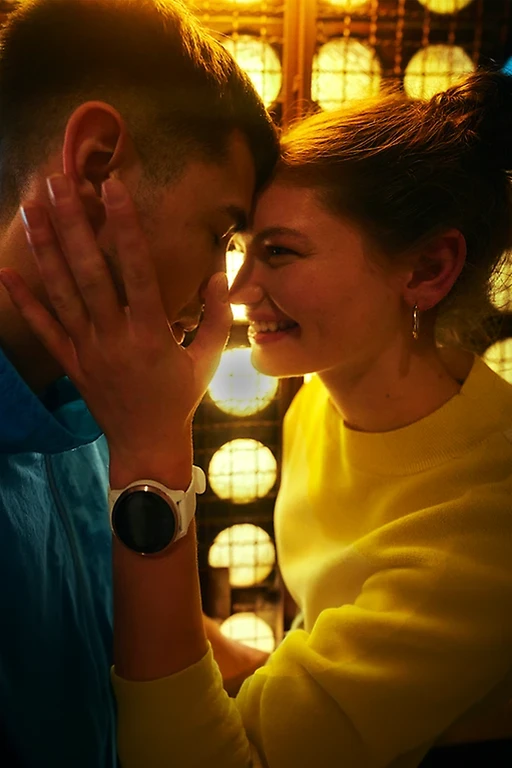  Eine Frau lächelt einen Mann an und legt ihre Hand an seine Wange. Er hat die Augen geschlossen. 