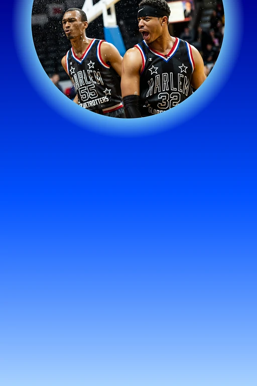  Zwei Harlem-Globetrotters-Spieler in schwarzen Trikots auf dem Spielfeld; der vordere jubelt mit offenem Mund, während feine Partikel durch die Luft fliegen und die Zuschauer unscharf im Hintergrund sind. 