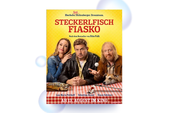  Filmplakat zu STECKERLFISCHFIASKO. Vor einem gelben Hintergrund sitzen drei Personen an einem rot-weiß karierten Tisch. In der Vor ihnen liegen zwei gegrillte Steckerlfische auf dem Tisch. Am rechten Bildrand schaut ein Hund über die Tischkante. 