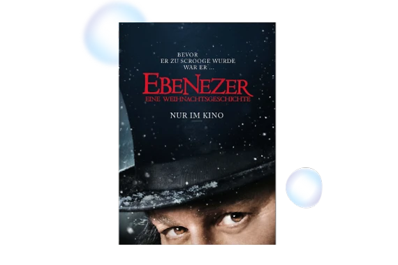  Filmplakat zu „Ebenezer – Eine Weihnachtsgeschichte“: Nahaufnahme eines Gesichts unter einem schwarzen Zylinderhut mit Schneeflocken. Auf dem Plakat steht: „Bevor er zu Scrooge wurde war er … Ebenezer – Eine Weihnachtsgeschichte. Nur im Kino.“ 