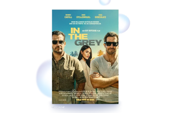  Auf dem Filmplakat "IN THE GREY" sind 3 Personen vor sonnigem, blauem Himmel und Palmen. Links und rechts 2 Männer mit Sonnenbrillen im Vordergrund. Mann rechts mit verschränkten, links mit herabhängenden Armen. In der Mitte, weiter hinten eine Frau mit langen dunklen Haaren & hellem Blazer. Oben stehen die Namen der Hauptdarsteller. Darunter Wenn Milliarden gestohlen werden, sind sie die Profis, die sie zurückstehlen. Mittig EIN GUY RITCHIE FILM & Filmtitel. Unten Credits und BALD NUR IM KINO. 